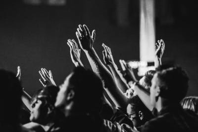 people with their hands raised in worship